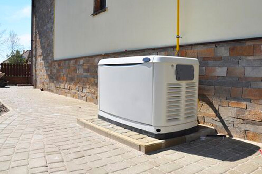 White generator on a patio outside of a house