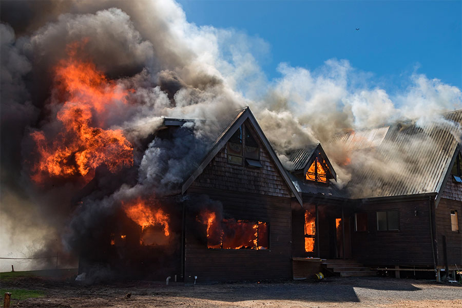 House on fire with smoke and flames shooting in the air