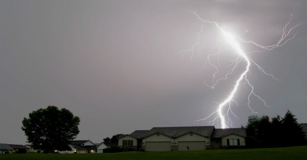 Lightning strike nearby and behind a home.