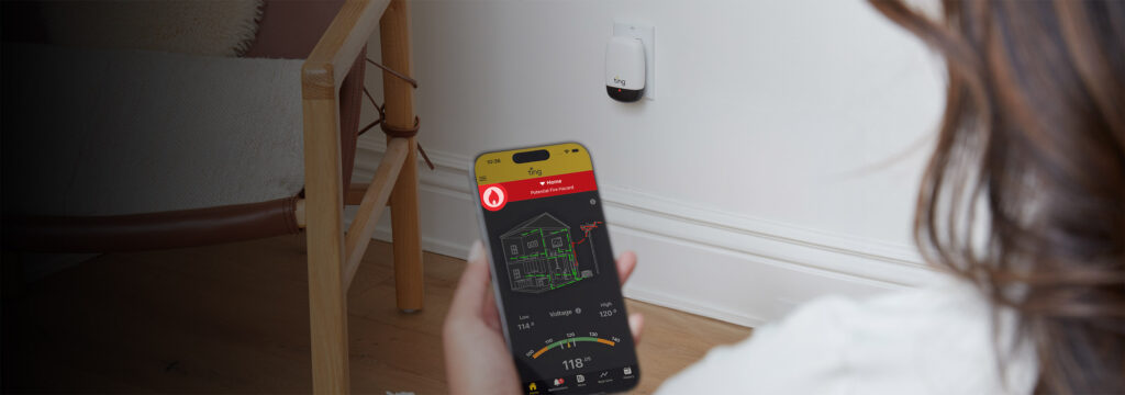 A woman holding a phone with the Ting Sensor app open showing a red fire hazard detected screen with Ting sensor plugged in in the background.