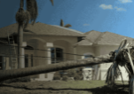 Is Your Home’s Electrical System Prepared for Hurricane Season? Residential home with roof damage from a hurricane and a fallen palm tree on power lines.